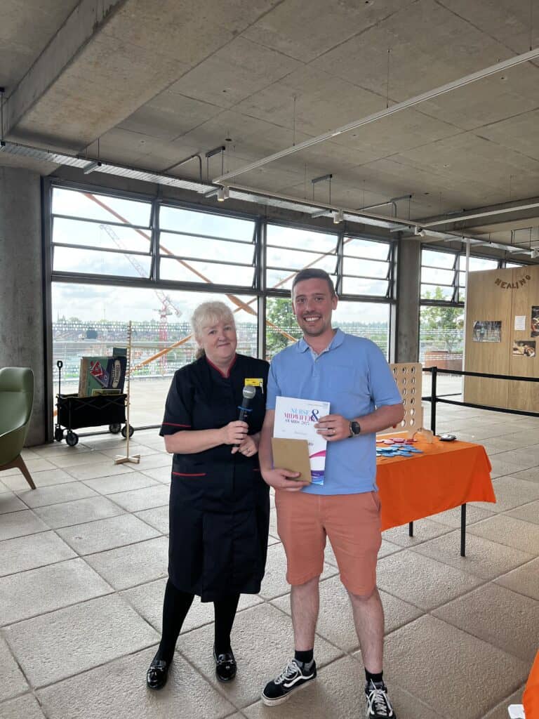 Lady smiling next to a gentleman who is holding a certificate
