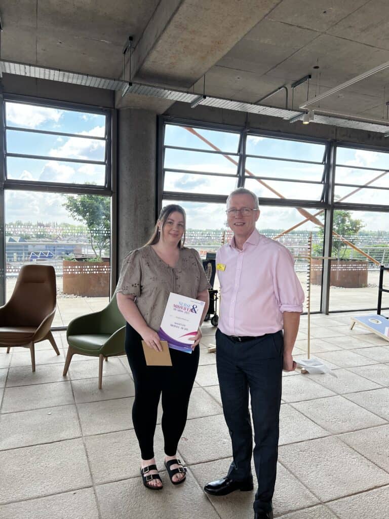 Lady who is smiling next to a gentleman holding a certificate