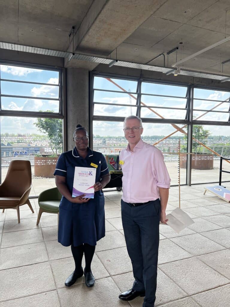 Lady who is smiling next to a gentleman holding a certificate