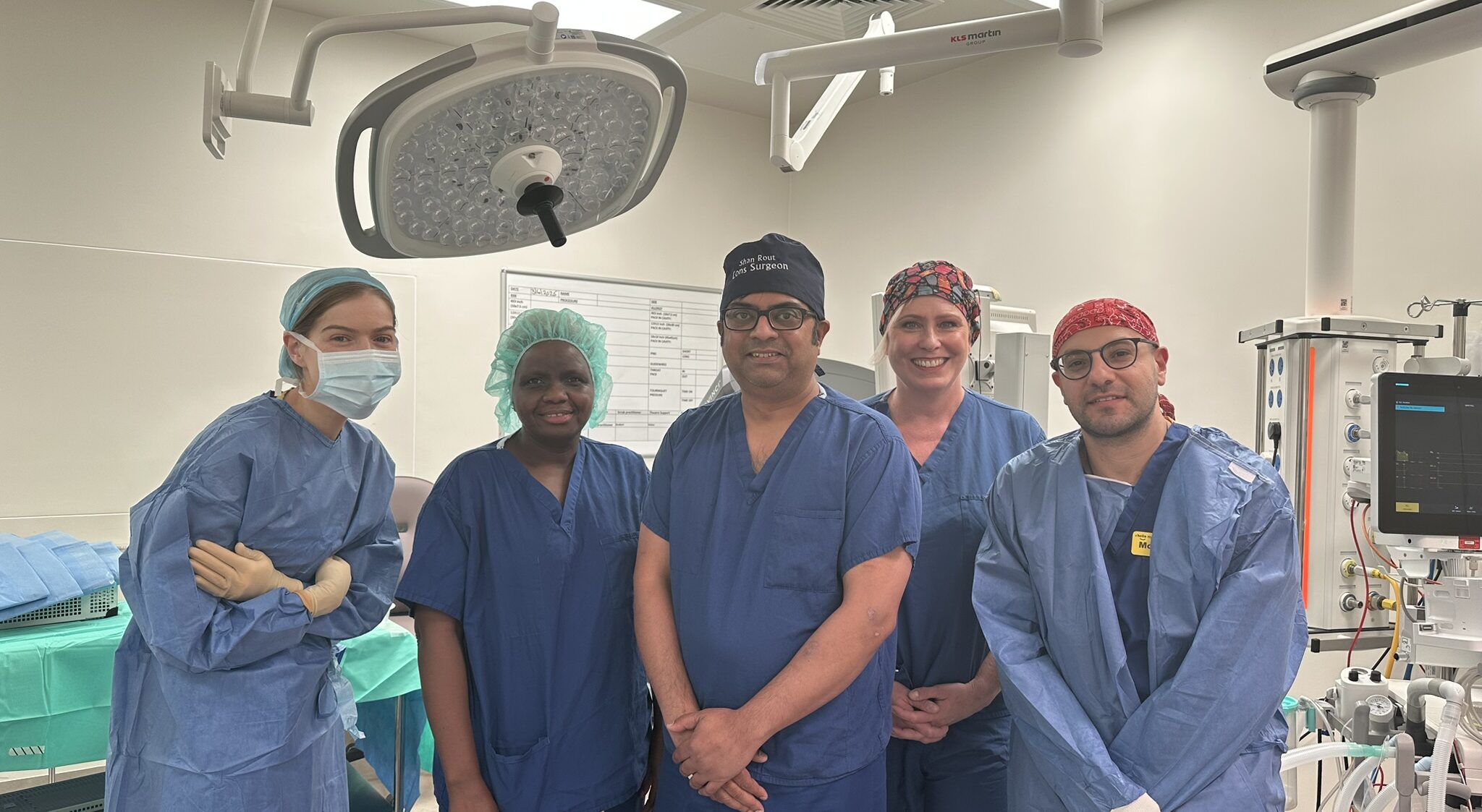 A group of healthcare workers in scrubs inside a general surgery theatre.