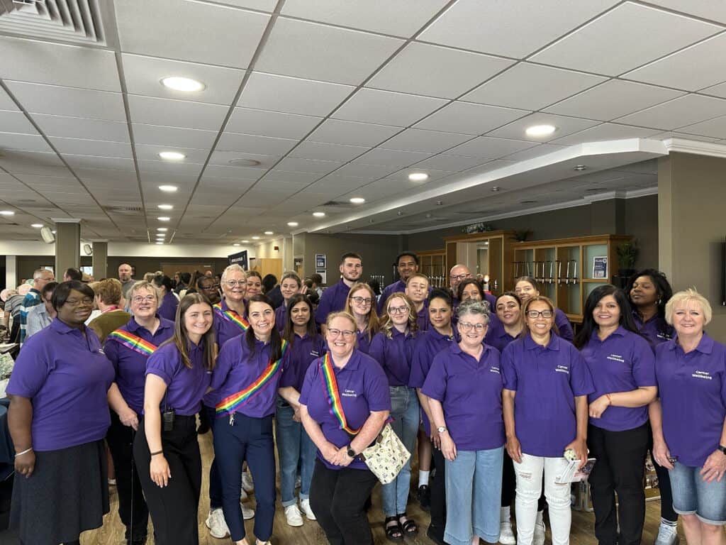 A group of volunteers in purple polo shirts.