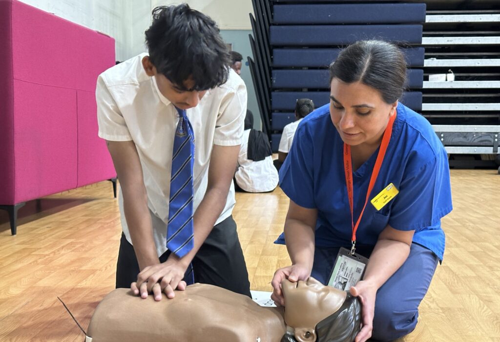 A student is shown how to perform CPR