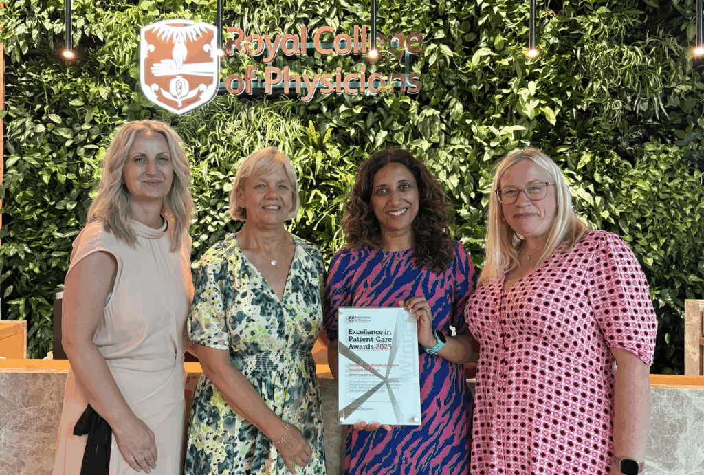 A photo of four women with an award they have won at an awards ceremony.