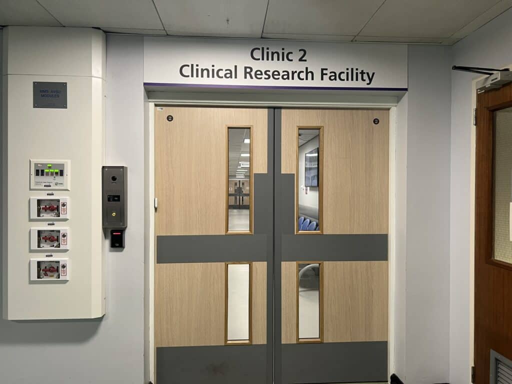 An image of double doors with a sign that says Clinical Research Facility.