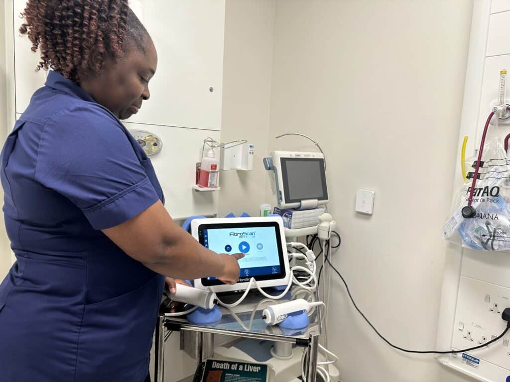 A nurse preparing an ultrasound machine.