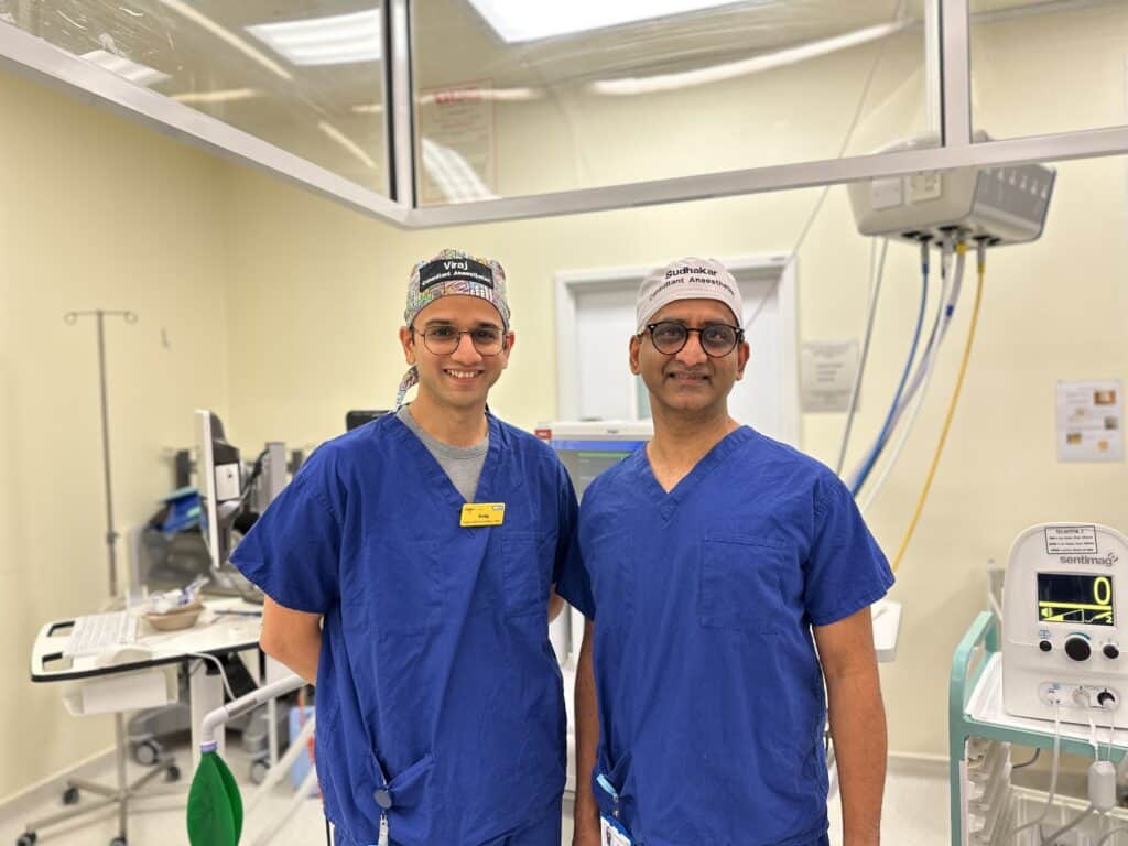 Two consultant anaesthetists in scrubs in an operating theatre.