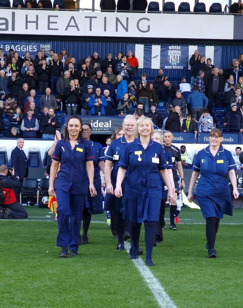 Cancer nurses walking onto the pitch at West Bromwich Albion FC.
