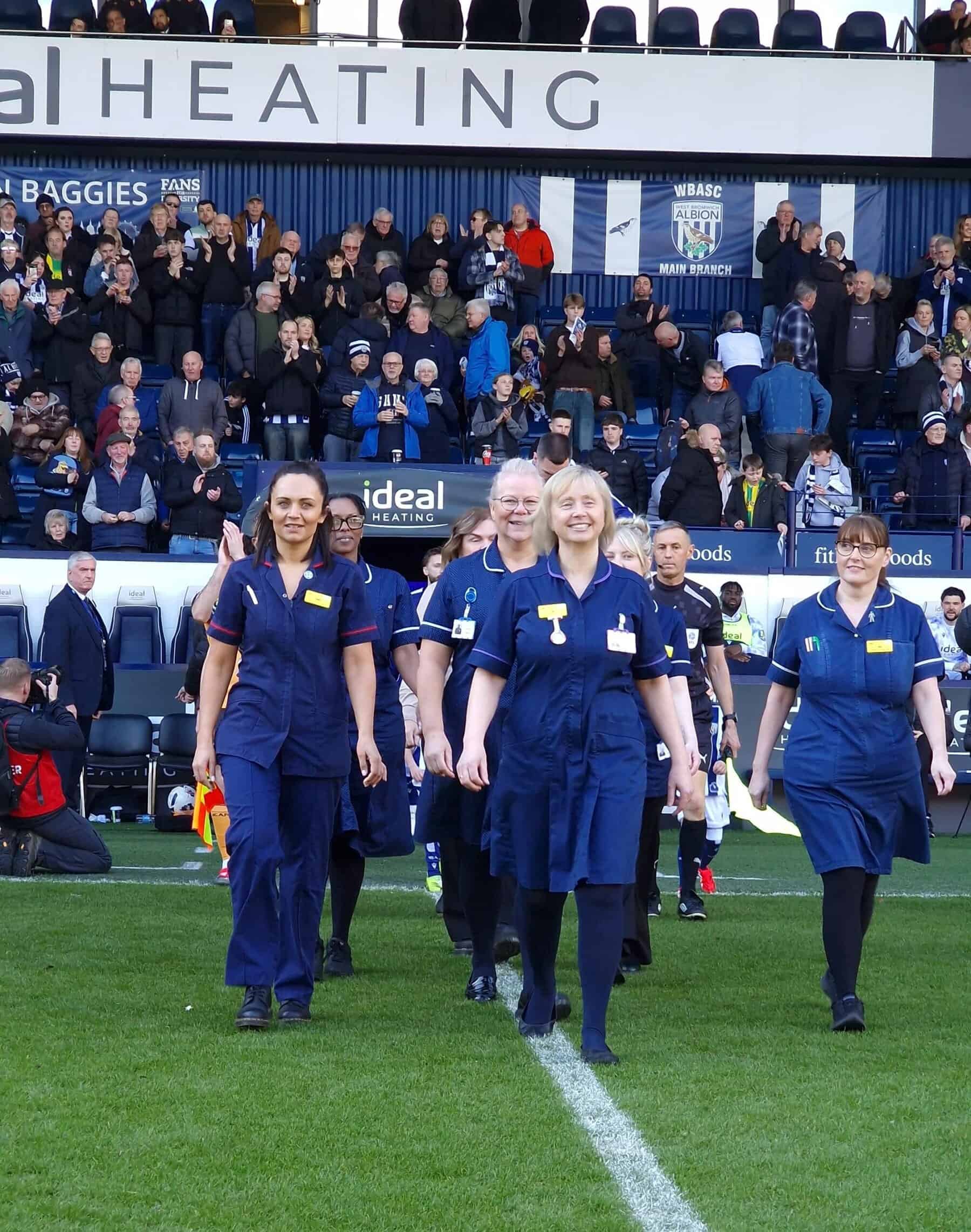 Cancer nurses walking onto the pitch at West Bromwich Albion FC.